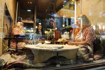 Turkey, Istanbul, Beyoglu, Taksim District, woman making bead in a restaurant window in Istiklal Caddesi Street