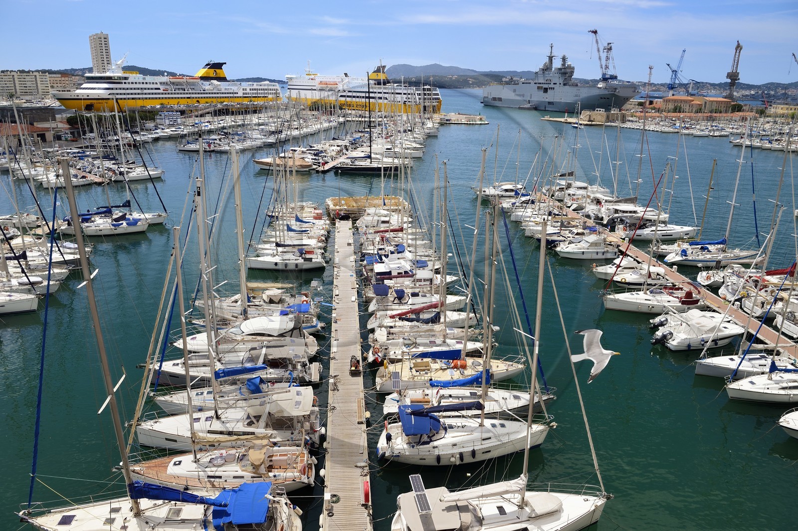 France, Var, Toulon, quai Kronstadtthat gives on the civil port, in the background on the left the commercial port and ferries to Corsica, in the background on the right the naval base and the Mistral (L9013) amphibious helicopter carrier of the French Navy in the background