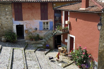 France, Alpes-Maritimes (06), Coaraze, labellisé Les Plus Beaux Villages de France, enfant partant à l'école dans les rues en escalier