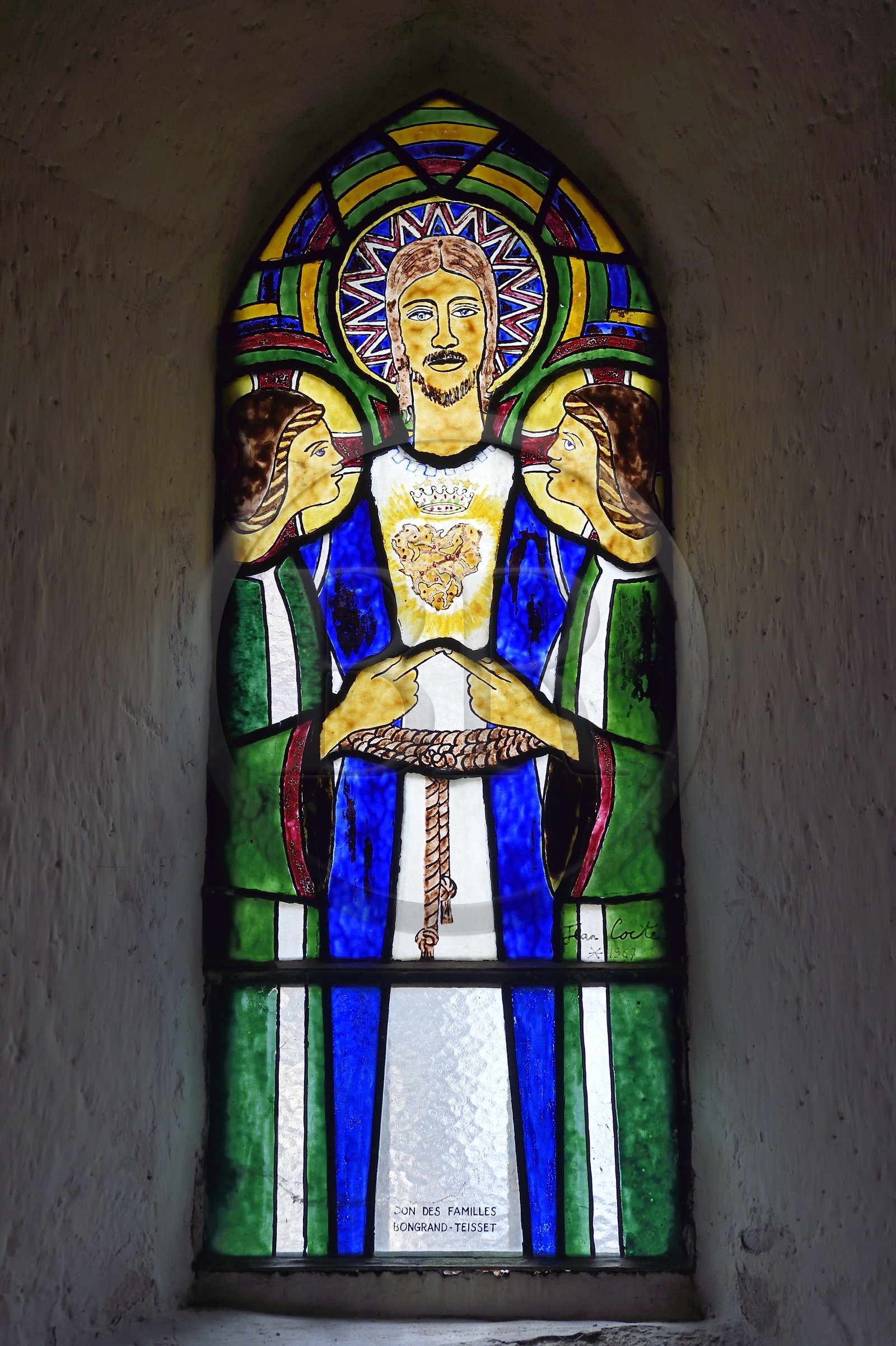 France, Cantal (15), Sainte-Marie, église Sainte-Agathe, vitrail dessiné par Jean Cocteau et réalisés à Saint Jean Cap Ferrat dans les ateliers Pelissier, le Christ entouré de deux anges dont les index se rejoignent représente un Sacré Coeur