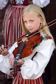 Sweden, Dalarna County, Leksand area, Midsummer celebrations in the tiny hamlet of Hjulbäck, girl in traditional dress playing the violin