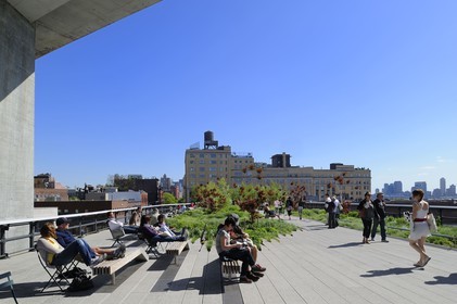 Etats-Unis, New York, Manhattan, Meatpacking district (Gansevoort Market), le High Line Park est une ancienne voie-ferrée aérienne partiellement réhabilitée en parc urbain suspendu, la High Line passe sous le Standard Hotel et personnes se reposant sur des chaises longues
