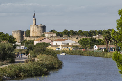 France, Gard, Aigues Mortes, the Rhone to Sète Canal and the medieval town surrounded by its ramparts, the Tower of Constance in the background