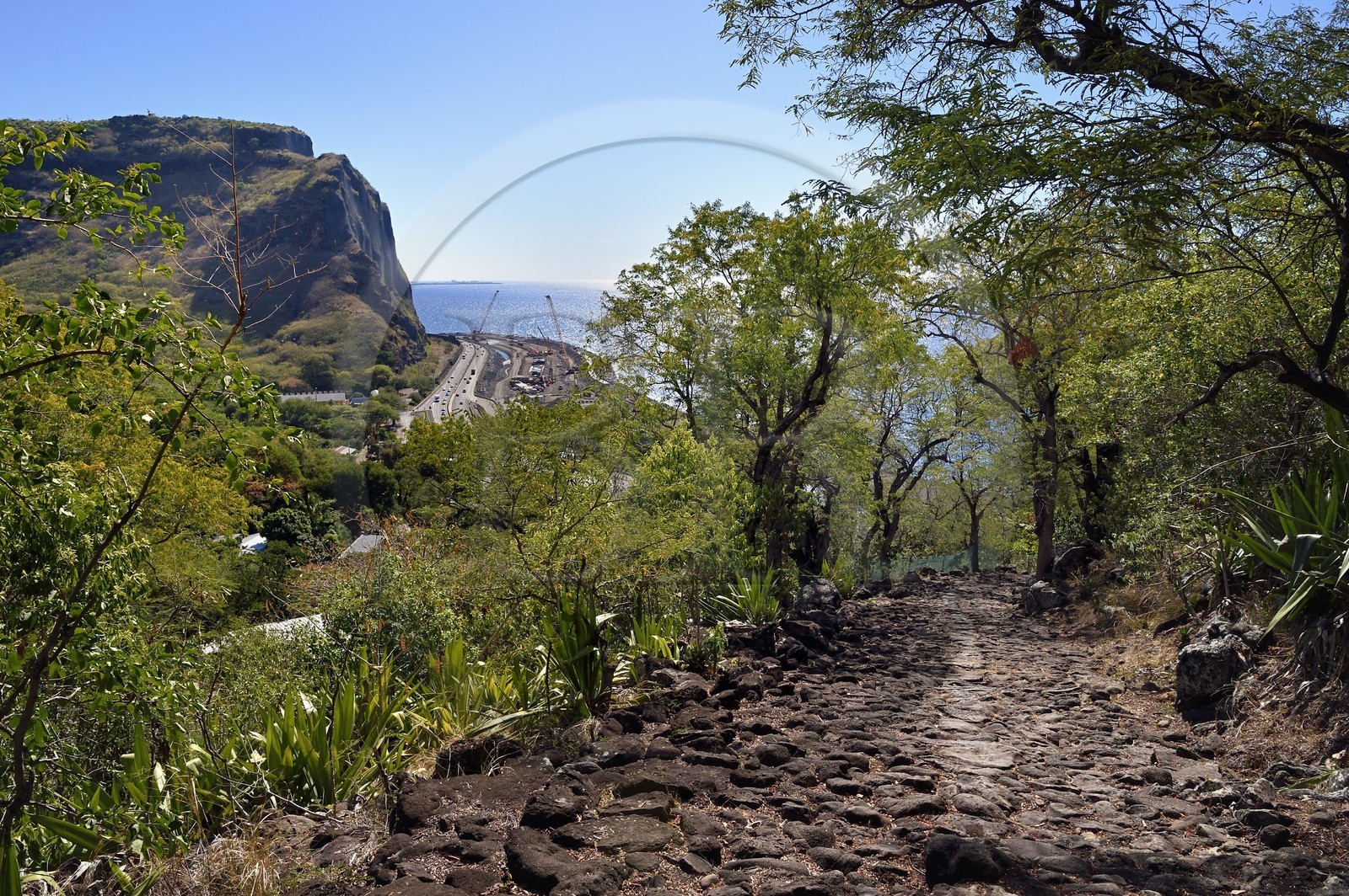 France, Ile de la Reunion, La Possession, ravine de la Grande Chaloupe, le chemin Crémont aussi appelé chemin des Anglais, ancienne route pavé de basalte depuis 1775, la route du littoral du XXème siècle et le chantier de la Nouvelle Route du Littoral (NRL) du XXIème siècle en arrière plan