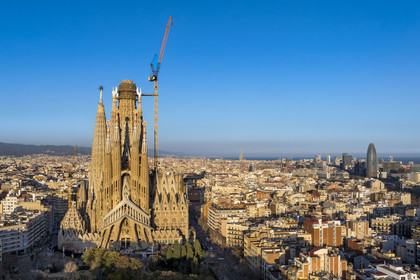 Spain, Catalonia, Barcelona, Eixample district, Sagrada Familia basilica by Catalan modernist architect Antoni Gaudi, listed as a UNESCO World Heritage Site, the passion facade, the Torre Agbar by architect Jean Nouvel in the background