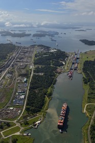 Panama, province de Colon, Canal de Panama, cargo Panamax passant les écluses de Gatun, le chantier des nouvelles écluses sur la gauche et le lac Gatun en arrière plan (vue aérienne)