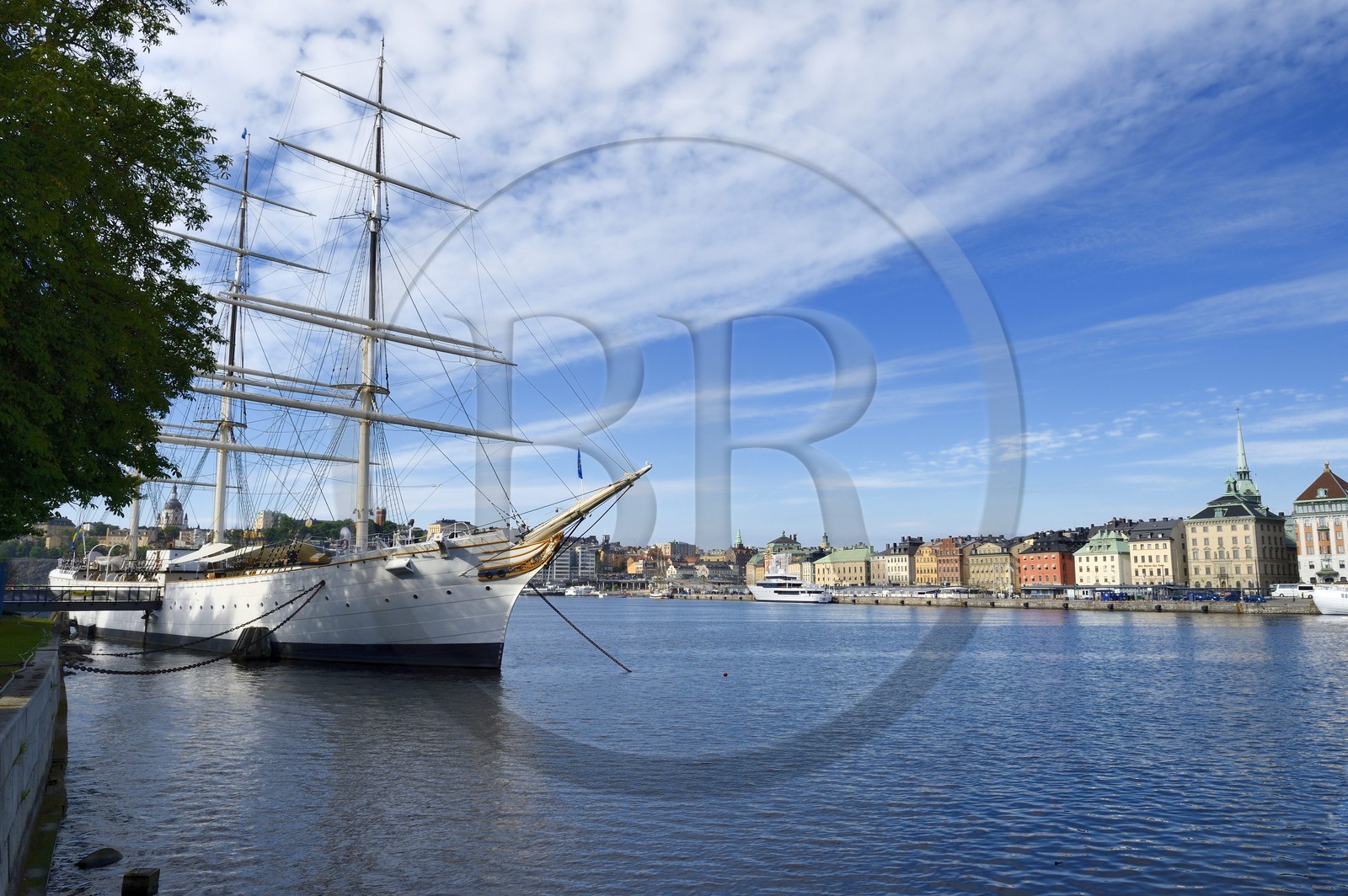 Suède, Stockholm, le voilier STF Vandrarhem af Chapman reconverti en auberge de jeunesse sur l'île de Skeppsholmen et la vieille ville dans l'île de Gamla stan à droite