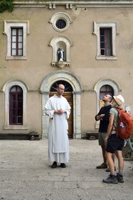 France, Var, Plan d'Aups Sainte Baume, Sainte-Baume Regional Nature Park, Sainte Baume massif, Brother Patrick-Marie Bozo, the prior of the Dominican community of Sainte-Baume, on the forecourt of the cave sanctuary of Sainte Marie-Madeleine (St. Mary Magdalene) with hickers