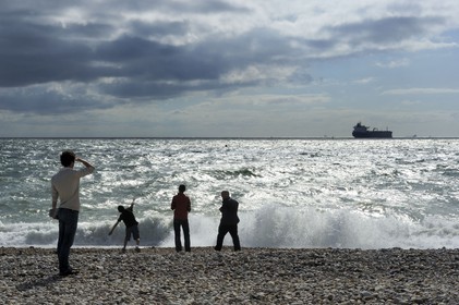 France, Seine-Maritime (76), Le Havre, cargo quittant le port du Havre vu de la plage de la ville
