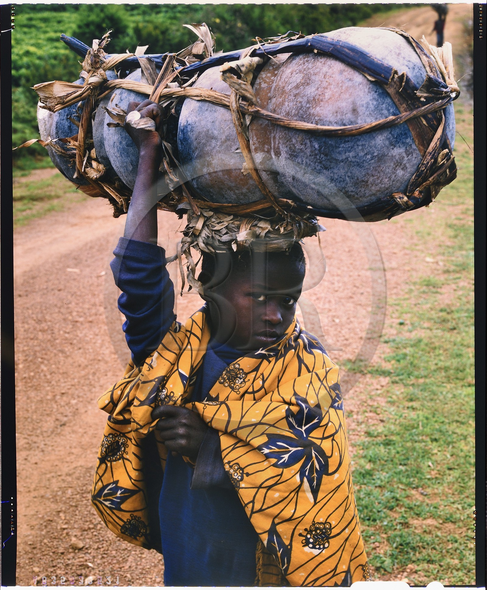 Burundi, province de Bujumbura, région d'Ijenda, jeune fille Twa (pygmée) se rendant au marché pour vendre ses pots en terre (reproduction plan-film inversible 4x5)