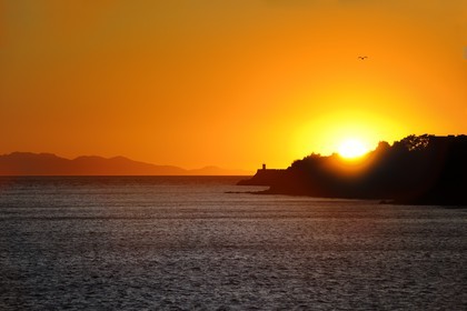 Italie, Toscane, l’Ile d’Elbe au coucher de soleil et la côte à Piombino en premier plan