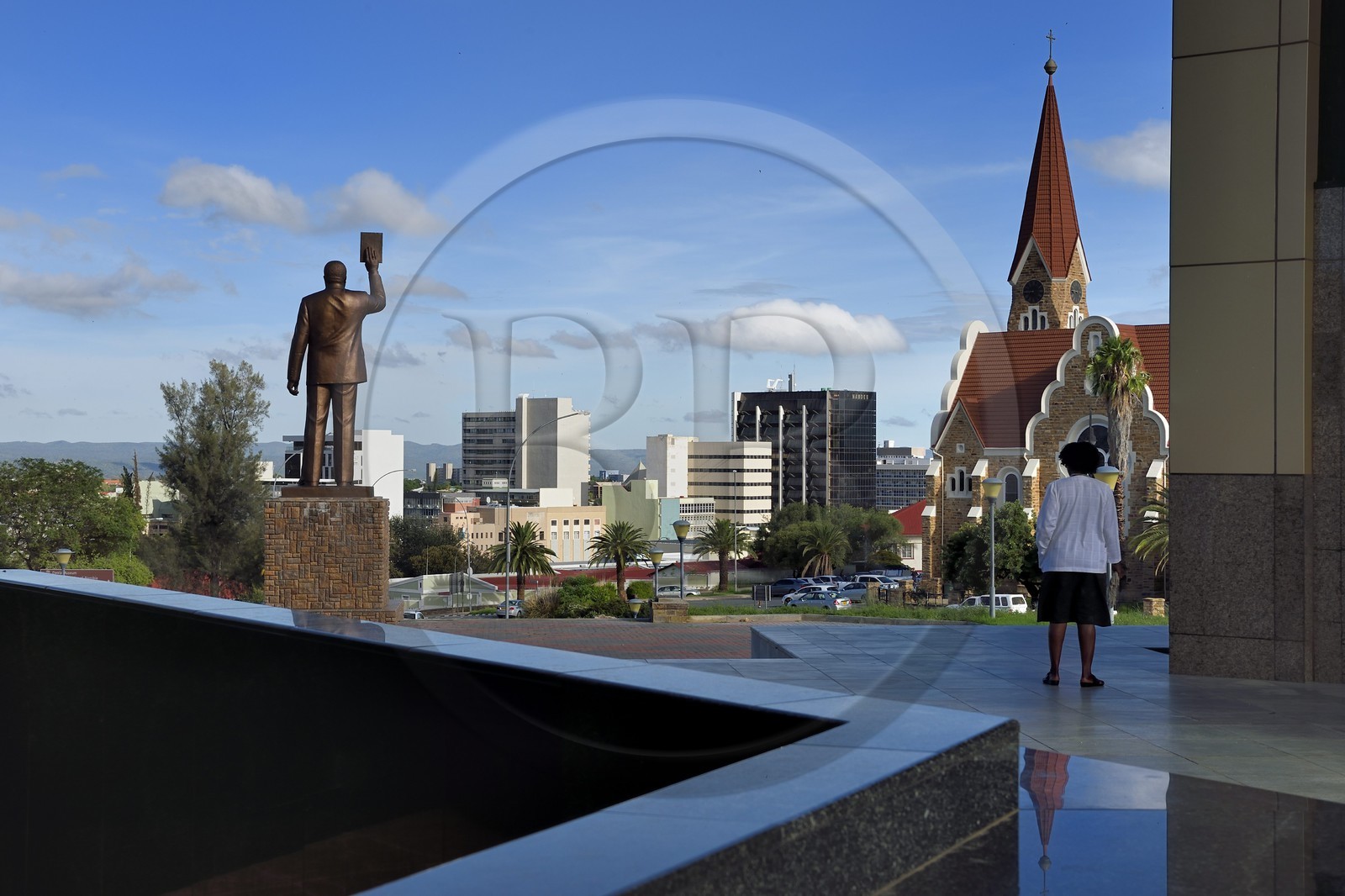 Namibia, Khomas region, Windhoek, Christ Church (or Christuskirche), Lutheran church designed by architect Gottlieb Redecker seen from the Independence Memorial Museum built by North Korea and statue of Dr Sam Nujoma (founding président of the Namibian nation)