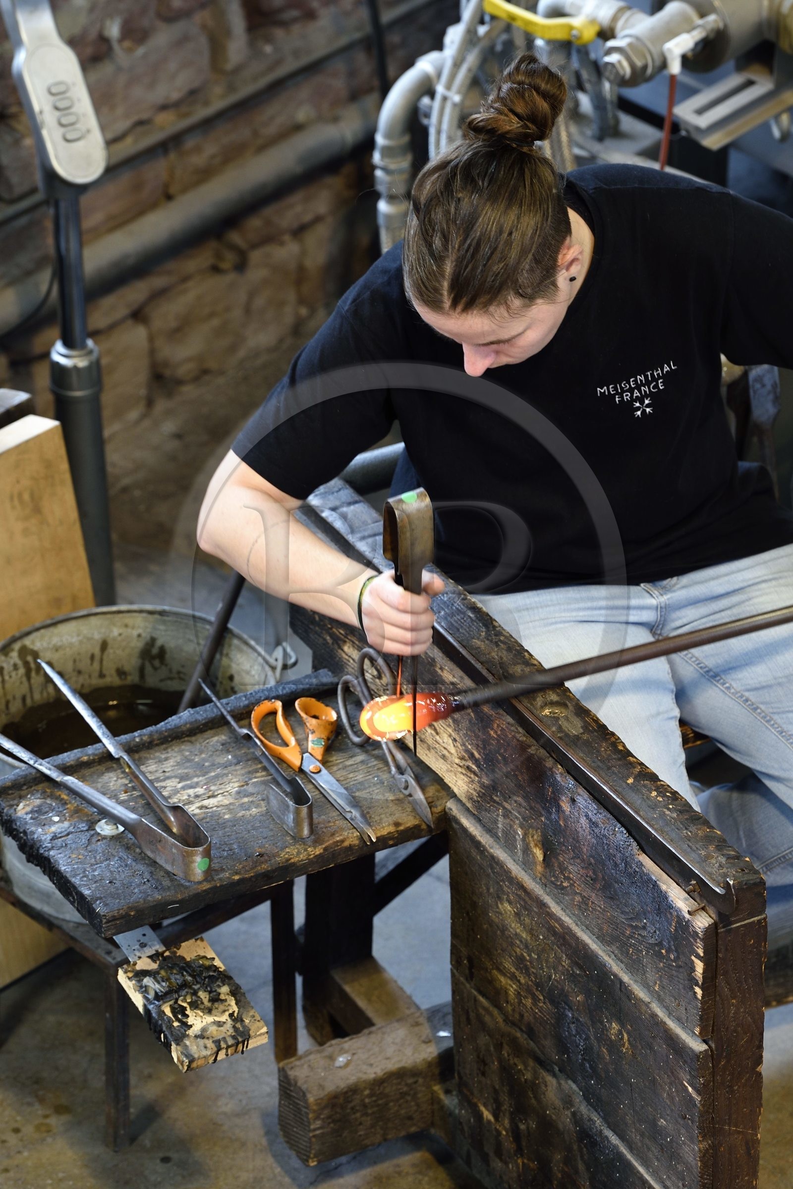 France, Moselle (57), Meisenthal, Centre international d’Art verrier (CIAV), l'atelier de soufflage, fabrication artisanale d'une boule de Noël, le souffleur régularise la masse au marbre tout en effectuant une rotation continue de sa canne et préparation de la paraison avant le passage au moule
