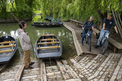 France, Vendée (85), Maillezais, cycliste en discussion avec un batelier tenant sa pigouille (perche en bois) au Grand Port, embarcadère de l'Abbaye