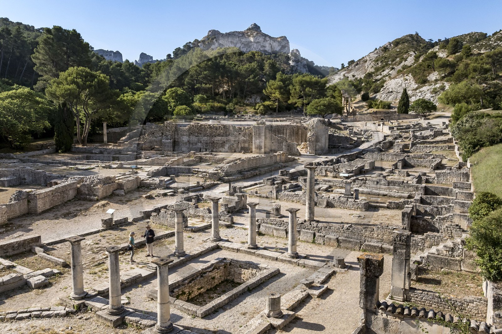 France, Bouches-du-Rhône (13), Parc Naturel Régional des Alpilles, Saint-Rémy-de-Provence, site archéologique de Glanum au pied du massif des Alpilles, Bernard Le Magouarou administrateur du site archéologique présente la maison des Antes avec péristyle et bassin au premier plan (vue aérienne)