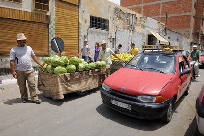 Maroc, région de l'Oriental, Oujda, vendeurs de pastèques et petit taxi
