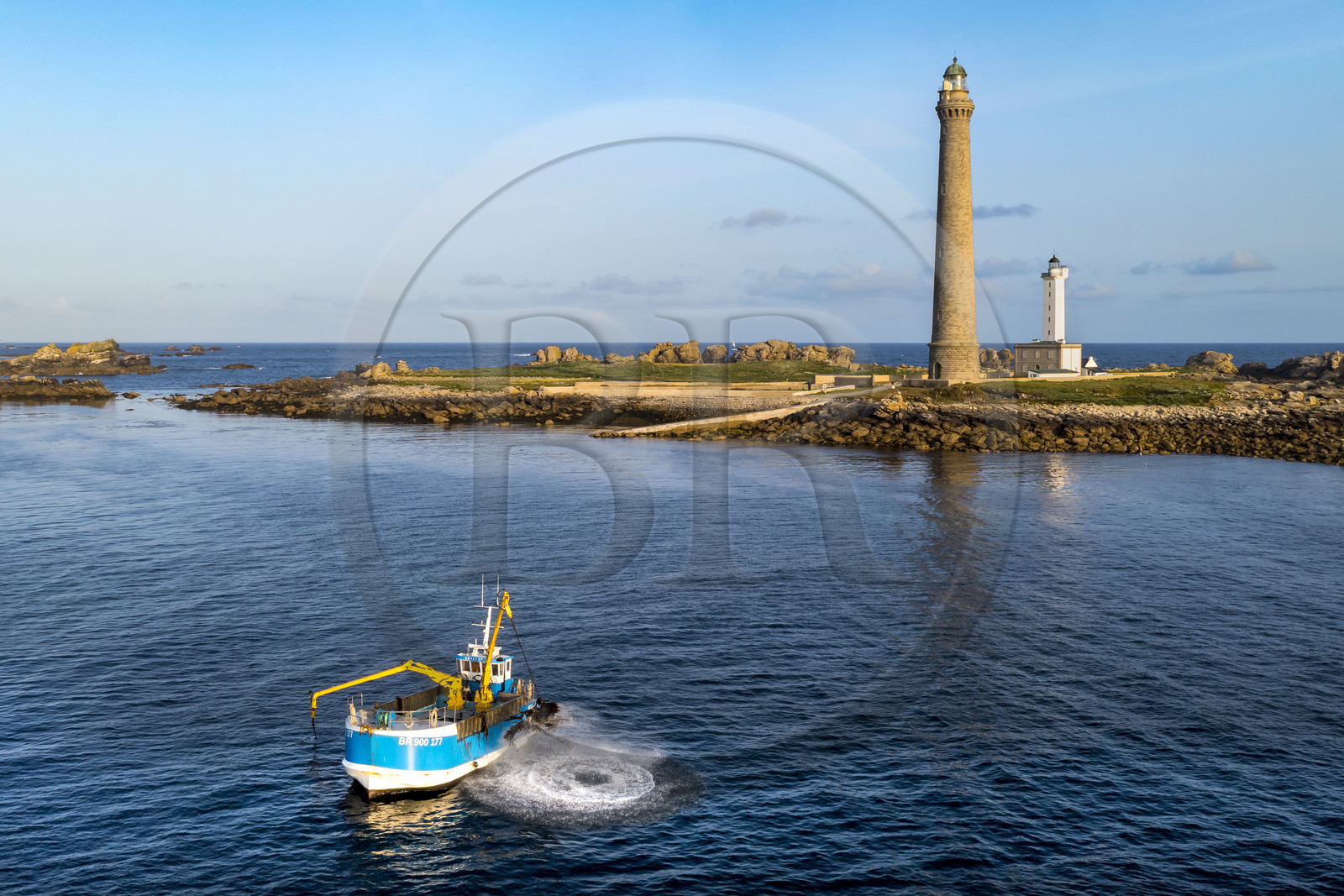 France, Finistère (29), Pays des Abers, Ile Vierge dans l'archipel de Lilia, bateau goémonier utilisant un de ses deux bras mécaniques articulés se terminant par un scoubidou pour récolter des algues marines le goémon, le phare de l'Ile Vierge en arrière plan (vue aérienne)
