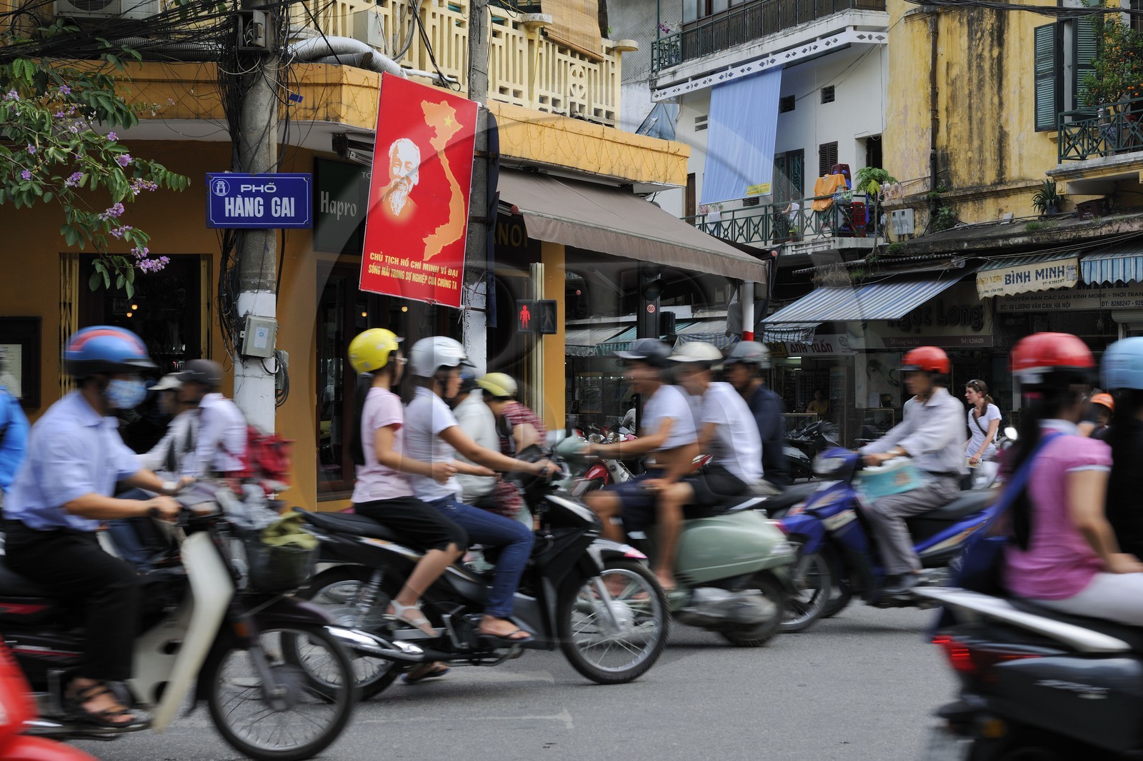 Vietnam, Hanoï, circulation en moto dans la vieille ville sous le regard d' Ho Chi Minh