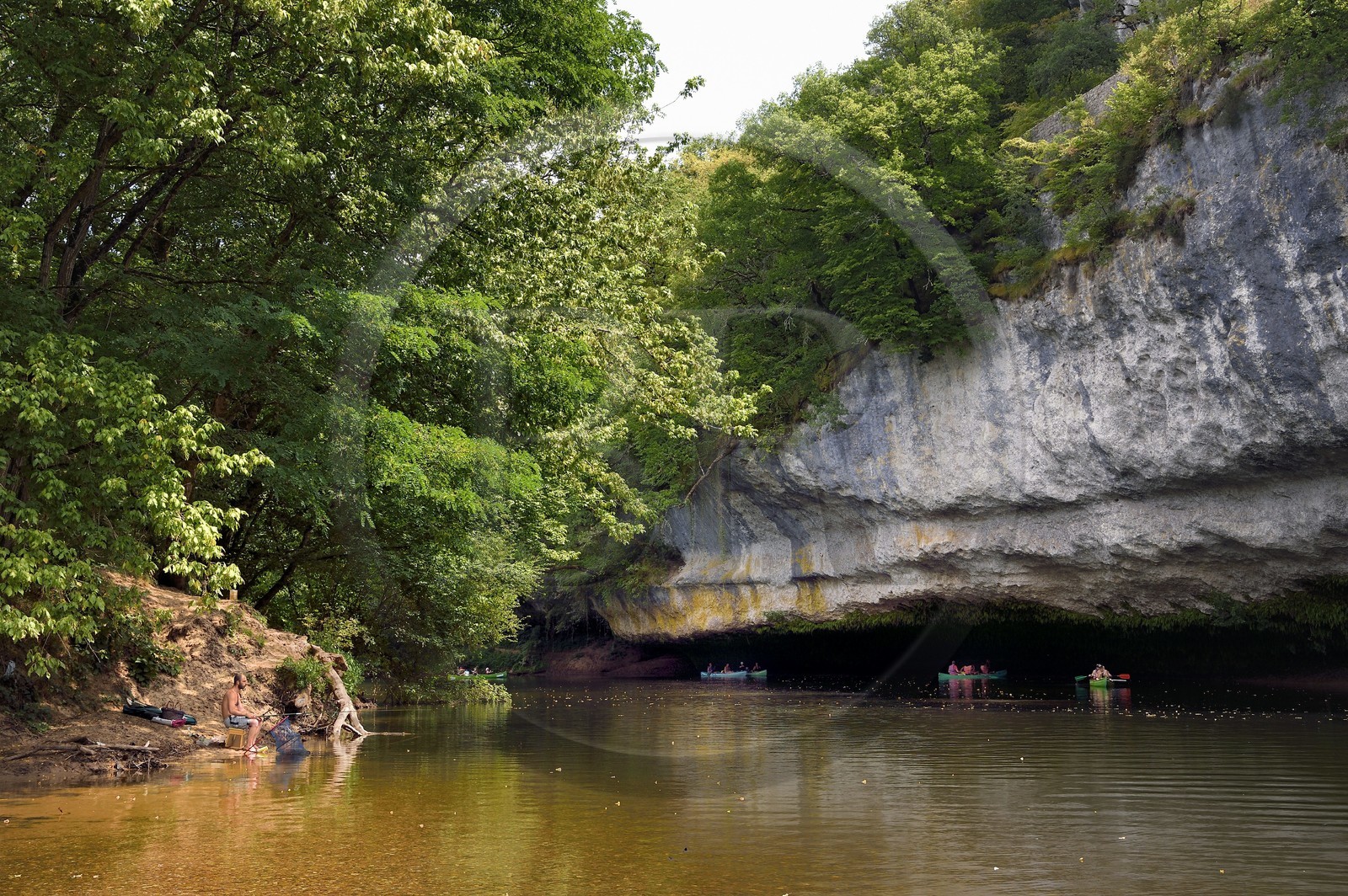 France, Dordogne, Perigord Noir, Vezere Valley at Peyzac le Moustier, canoeing on the Vezere river under the Roque Saint-Christophe cliffs