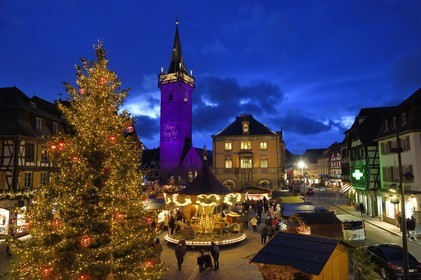 France, Bas Rhin, Obernai, Christmas market on the market square, Chapel Tower (Kappelturm) completed in the 16th century, serves as a belfry next to the town hall