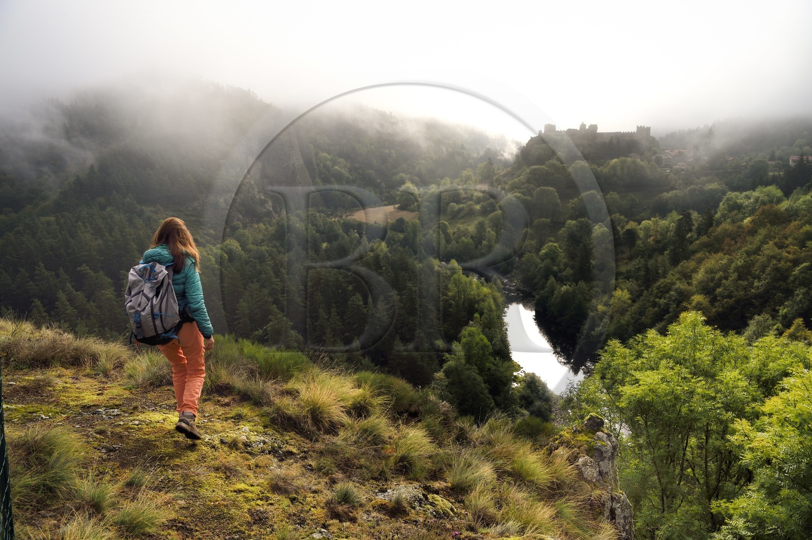 France, Haute-Loire (43), vallée de la Loire, Arlempdes, labellisé les Plus beaux villages de France, randonneuse observant les ruines du chateau perché sur un rocher basaltique qui surplombe un méandre de la Loire