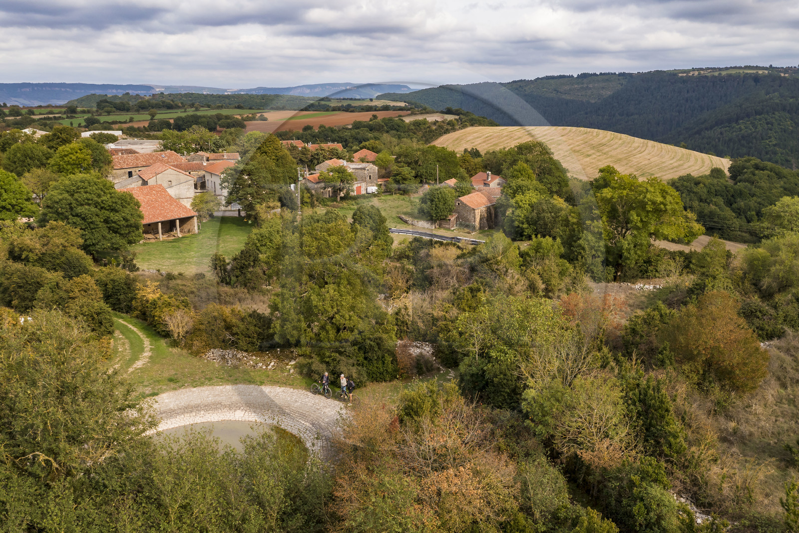 France, Aveyron, Grands-Causses Regional Nature Park, Versols et Lapeyre, the hamlet of Hermilix, in the foreground a lavogne, natural excavation sealed to collect rainwater and water livestock (aerial view)