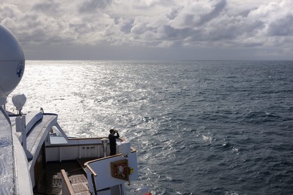 Iceland, toward Denmark Strait on board the cruise ship Princess Danae, an officer scans the horizon