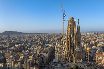 Spain, Catalonia, Barcelona, Eixample district, Sagrada Familia basilica by Catalan modernist architect Antoni Gaudi, listed as a UNESCO World Heritage Site, facade of the Nativity and Montjuic hill in the background