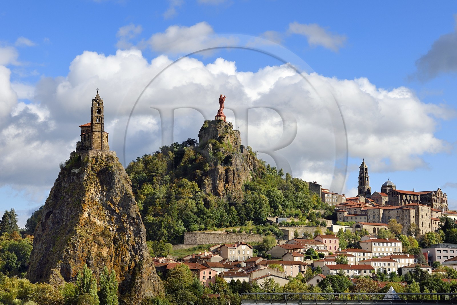 France, Haute Loire, Le Puy en Velay, Routes of Santiago de Compostela in France listed as World heritage by UNESCO, view of the city with the Saint-Michel d'Aiguilhe Chapel perched on a volcanic peak on the left, the Notre Dame de France statue (from 1860) on the Rocher Corneille overlooking the 12th century Notre Dame de l'Annonnement cathedral on the right