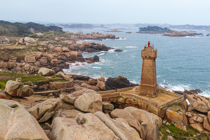 France, Cotes-d'Armor, Cote de Granit Rose, Perros-Guirec, Ploumanac'h, Pointe de Skewell (Squéouel), the Mean Ruz lighthouse on the Douaniers trail also GR 34 long-distance trail and the castle of Costaérès on its island in the background (aerial view)