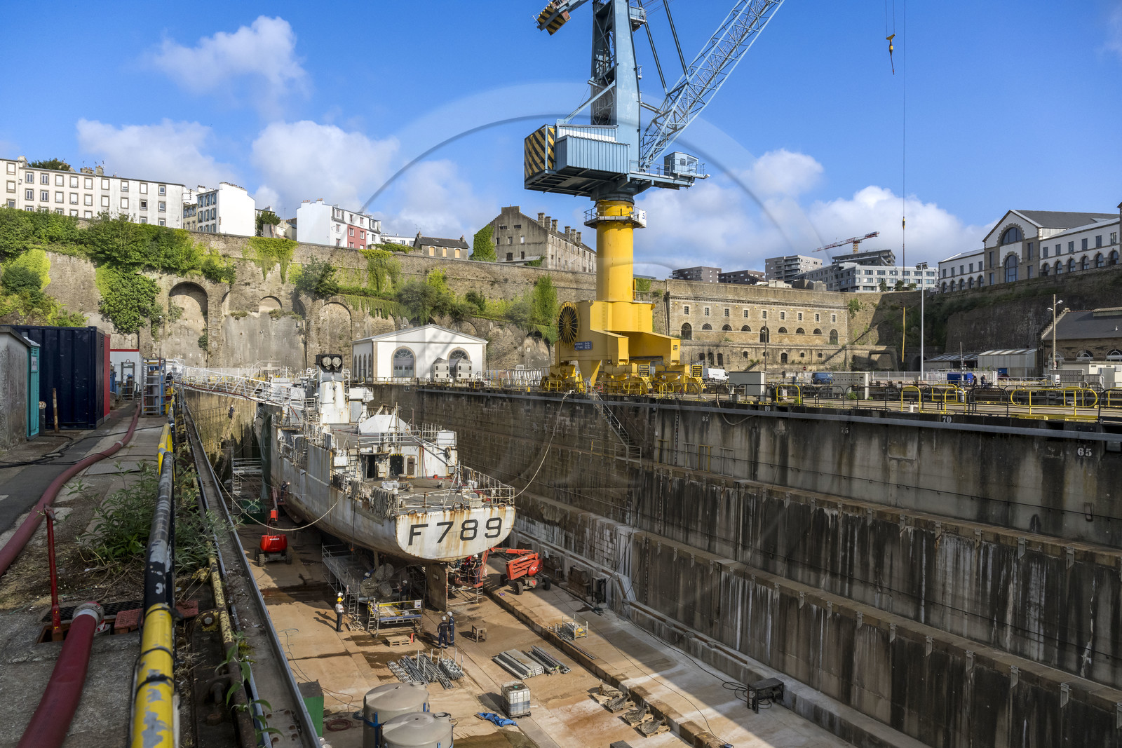 France, Finistère (29), Brest, l'arsenal, le port militaire est une base navale de la Marine nationale, navire de guerre en chantier dans un des deux bassins de radoub de Pontaniou situés dans l’anse de Pontaniou, le batiment aux Lions en arrière plan à droite