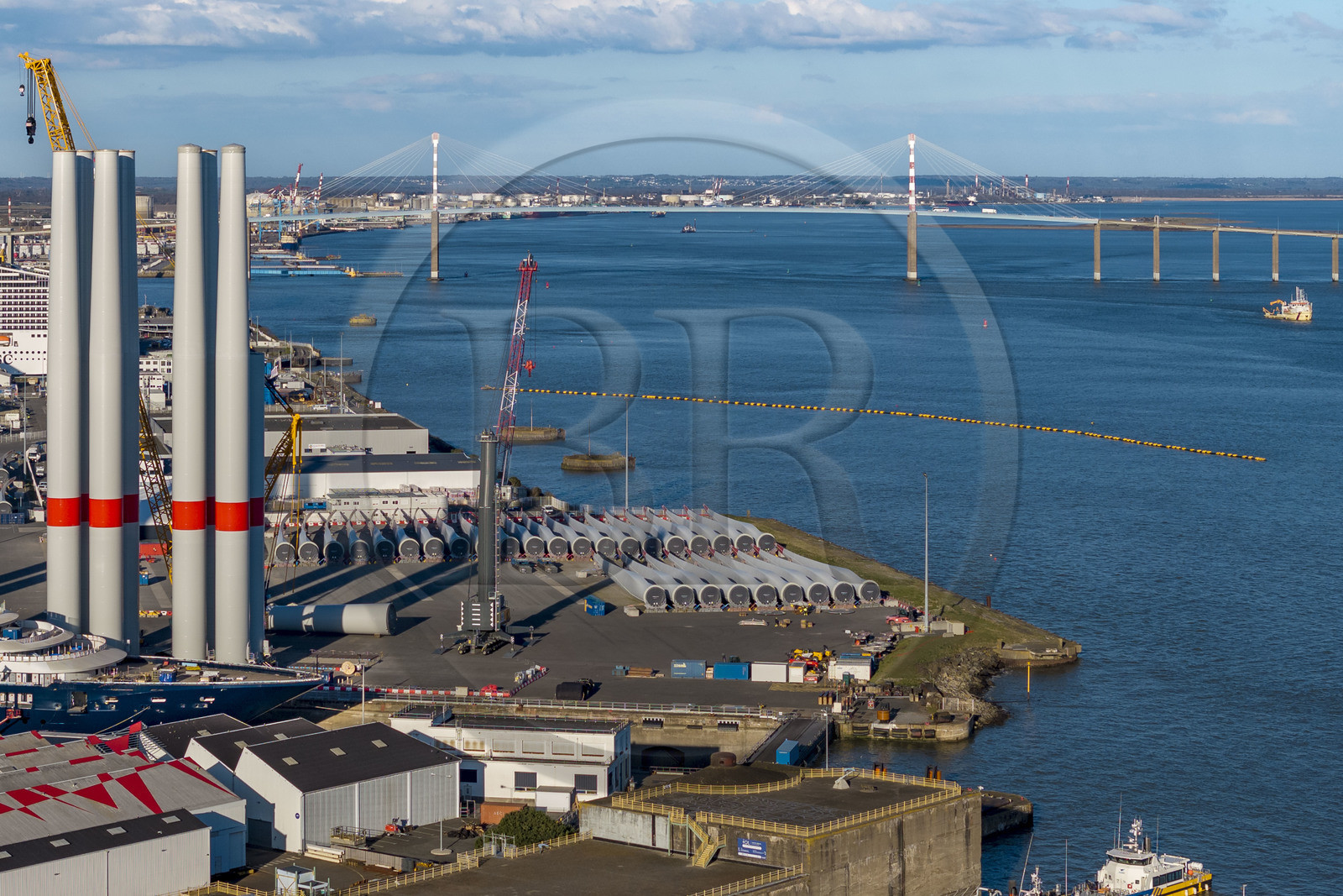 France, Loire-Atlantique (44), Saint-Nazaire, les tours d'éoliennes sont stockées avant embarquement, le pont de Saint-Nazaire en arrière plan (vue aérienne)