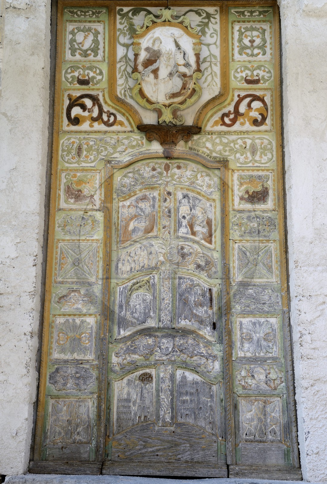France, Haute-Corse (2B), Castagniccia, village de Piazzole d'Orezza, église paroissiale de l'Annonciation, la tradition rapporte qu’un bandit repenti sculpta sur la jolie porte bariolée de l’église plusieurs scènes bibliques (l’annonce faite à Marie, David et Goliath) et un beau décor de vigne et de blé