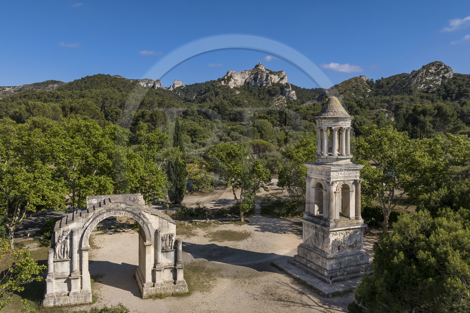 France, Bouches-du-Rhône (13), Parc Naturel Régional des Alpilles, Saint-Rémy-de-Provence, les Antiques de Glanum, cénotaphe gallo-romain érigé entre -30 et -20 av J.-C. élevé à la mémoire d'un homme de la famille des Julii et l'arc municipal de Glanum, arc de triomphe romain (vue aérienne)