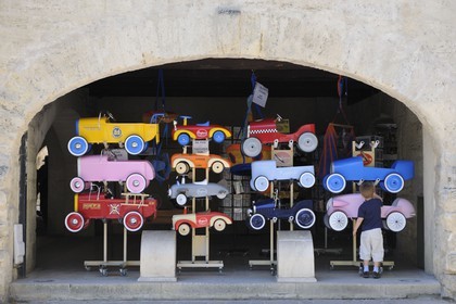 France, Gard, Uzes, pedal cars store on Place aux Herbes