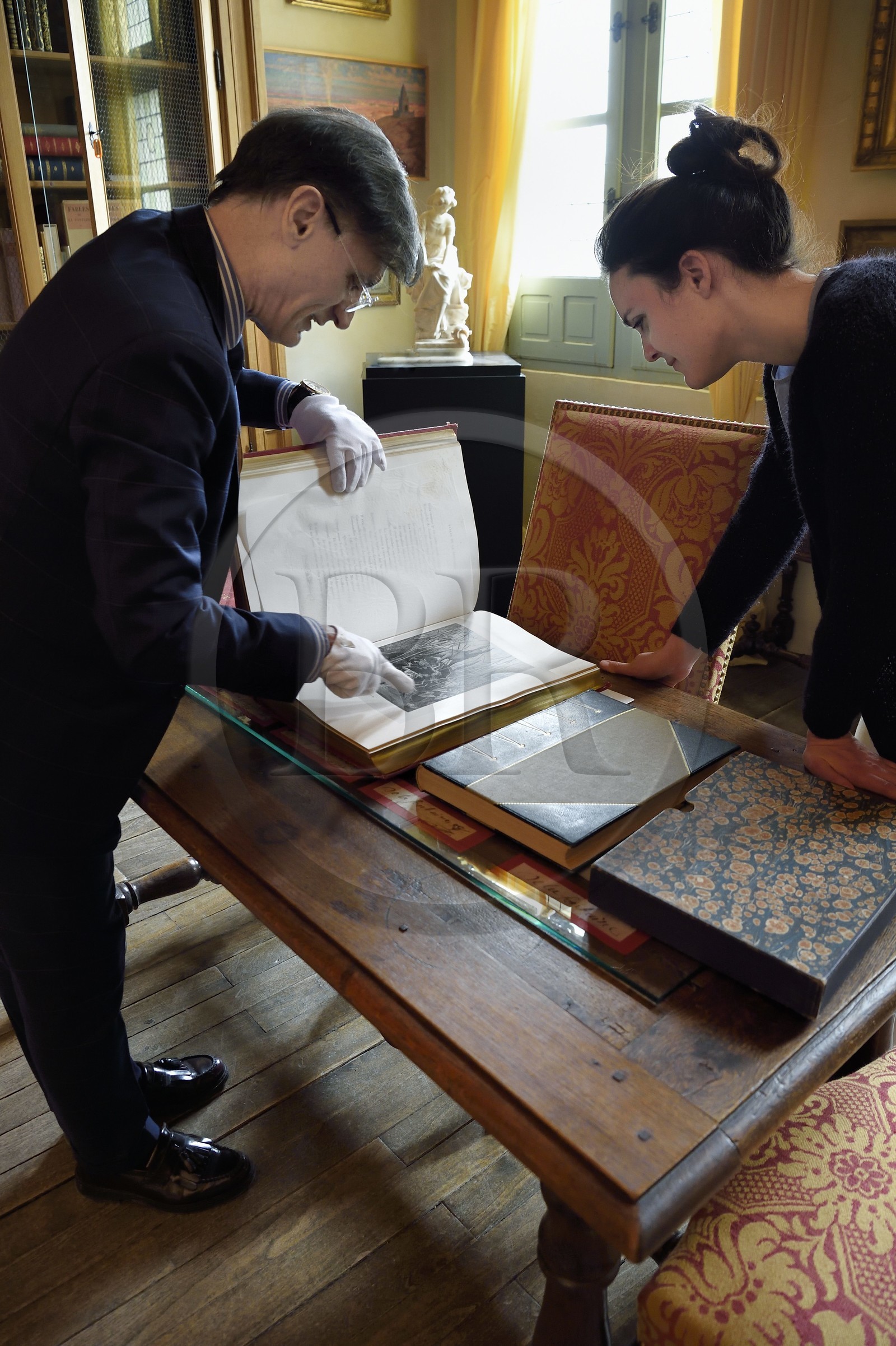 France, Aisne, Château-Thierry, Jean de La Fontaine Museum - city of Chateau-Thierry, the director of the museum pole Nicolas Rousseau and his deputy director Marie-Mileva Pavlovitch observing the La Fontaine's Fables book, illustrated edition (1867, in-folio) by Gustave Doré