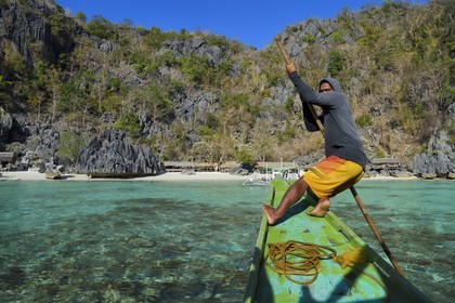 Philippines, Calamian Islands dans le nord de Palawan, Coron Island Natural Biotic Area, plage de Banul Beach au pied des murs géants des falaises de calcaire, batelier