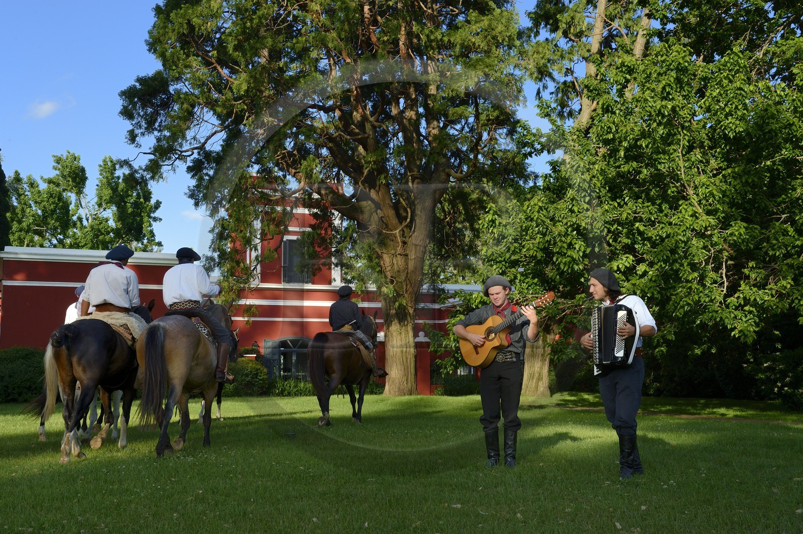 Argentine, province de Buenos Aires, San Antonio de Areco, groupe de gauchos à cheval devant l'estancia La Bamba de Areco et gauchos jouant des aires de Milongas sur leur guitare et accordéon
