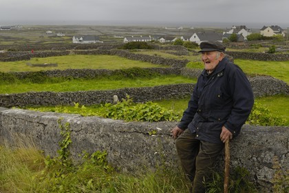 Irlande, Comté de Galway, Aran Islands, Inishmaan, murets typiques en pierres sèches délimitant chaque parcelle de terre, vieil homme