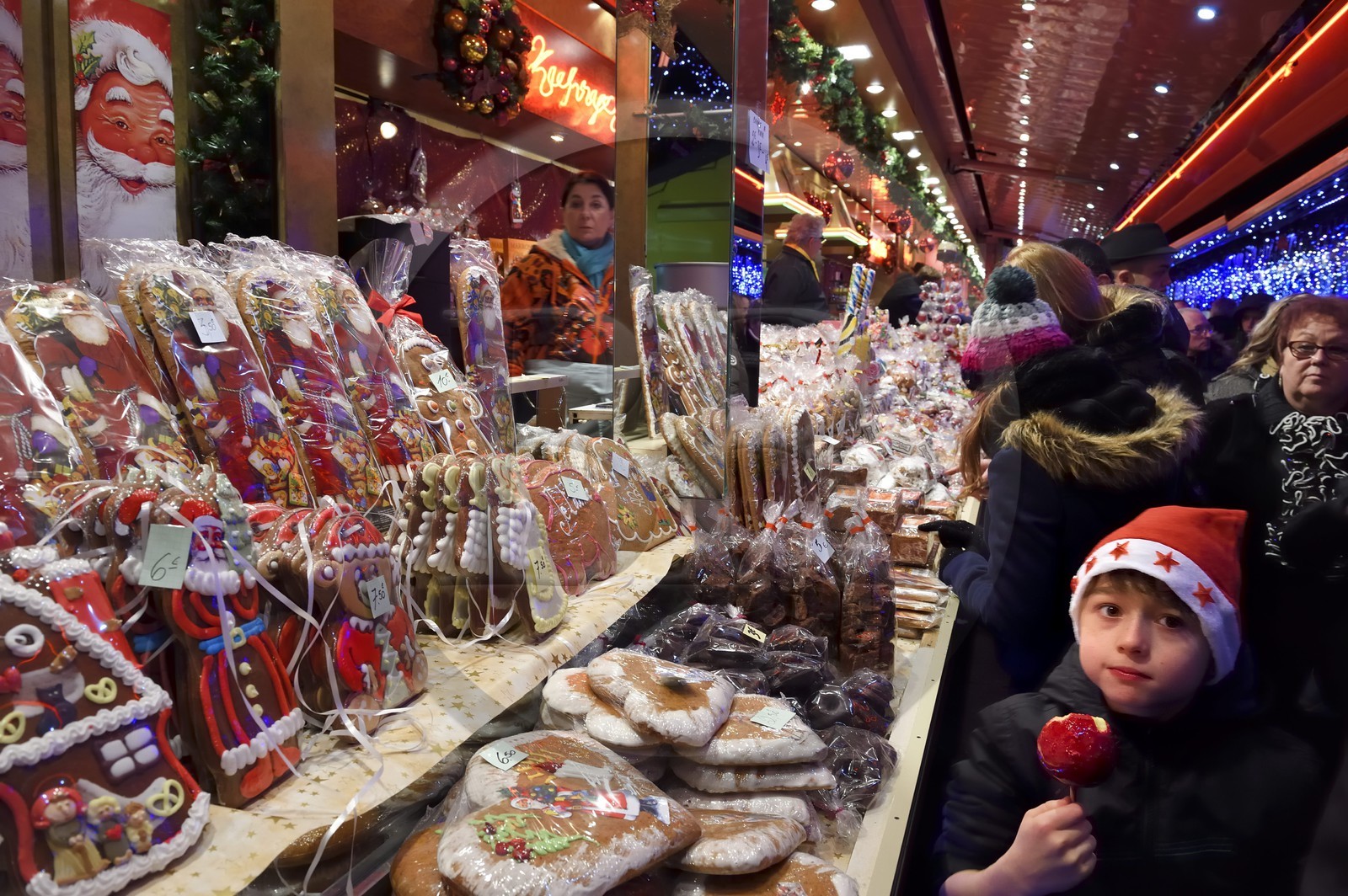 France, Bas Rhin, Strasbourg, old town listed as World Heritage by UNESCO, Christmas market (Christkindelsmarik) on the place Broglie, child eating a Candy apple