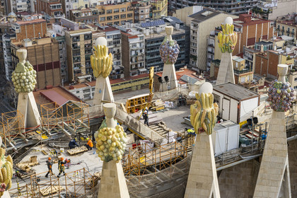 Espagne, Catalogne, Barcelone, quartier de l'Eixample, basilique de la Sagrada Familia de l'architecte du modernisme catalan Antoni Gaudi classée Patrimoine Mondial de l'UNESCO, sommets surmontés de mosaïques en forme de fruits entourant le chantier sur le toit de la nef à l'arrière de la future facade de la Gloire