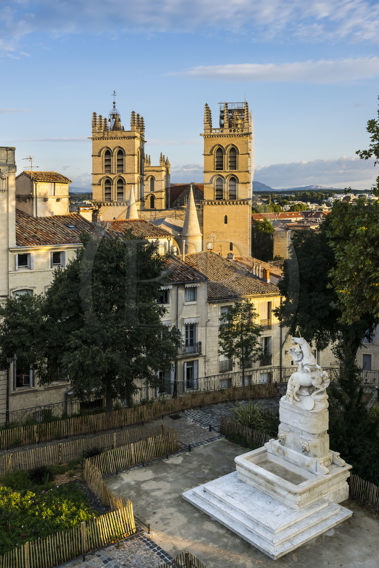 France, Herault, Montpellier, historic center called the Ecusson, the unicorn fountain in the garden of the Place du Canourgue and the towers of Saint-Pierre Cathedral in the background
