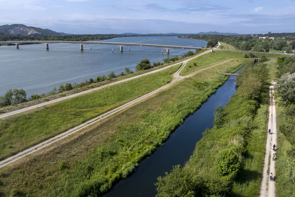 France, Gard, Aramon, cyclists on the ViaRhona cycle route and the Aramon bridge over the Rhone in the background (aerial view)