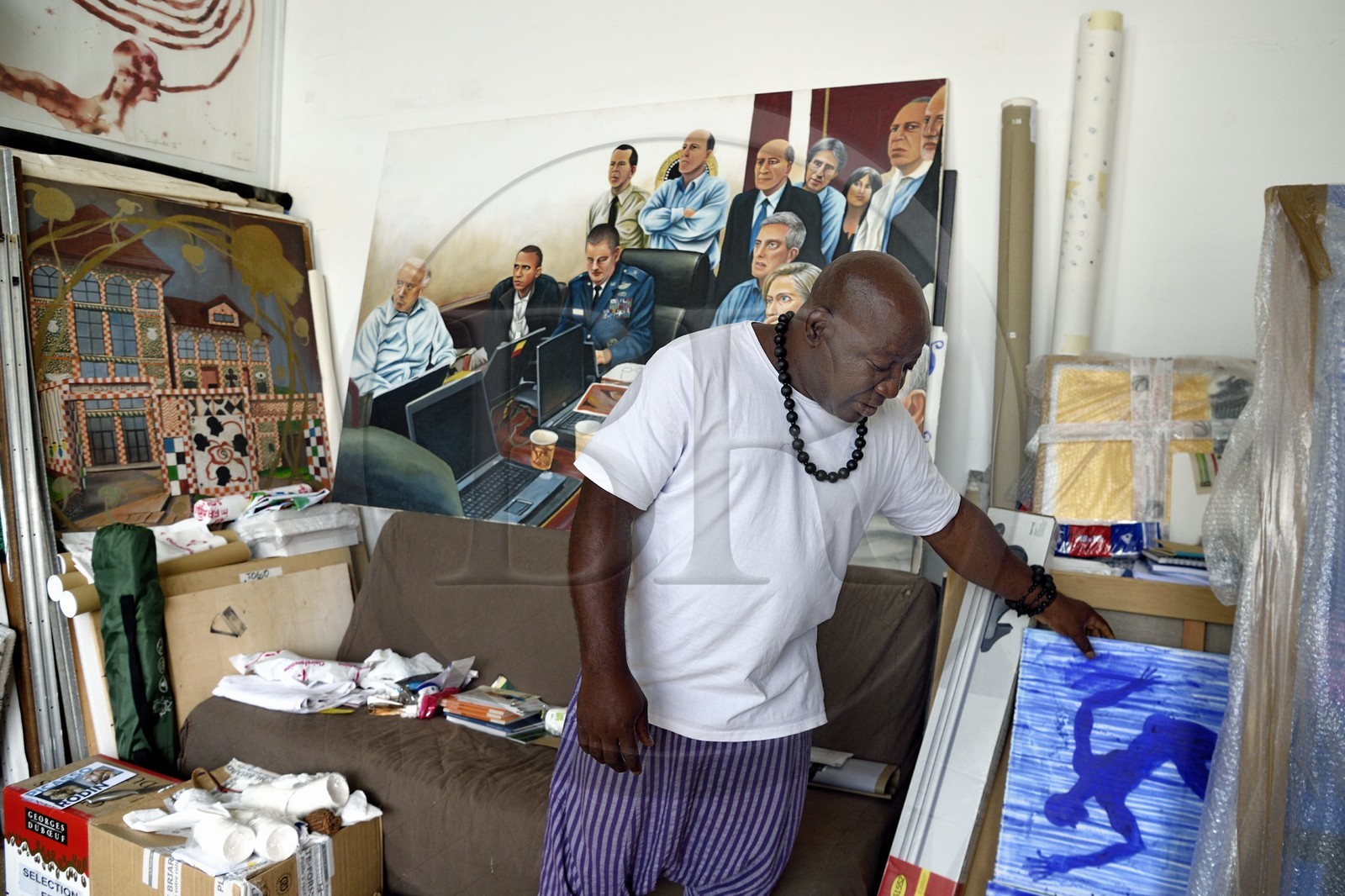 France, Paris (75), Barthelemy Toguo, l'artiste fondateur de Bandjoun Station au Cameroun (représenté dans la peinture en arrière plan), dans son atelier parisien