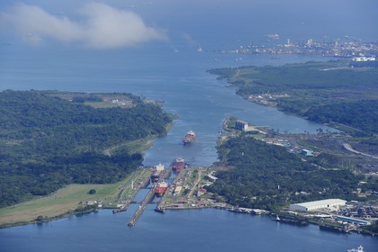 Panama, province de Colon, Canal de Panama, cargo Panamax passant les écluses de Gatun, la baie Limon (Bahia Limon) coté Atlantique et la ville de Colon en arrière plan (vue aérienne)