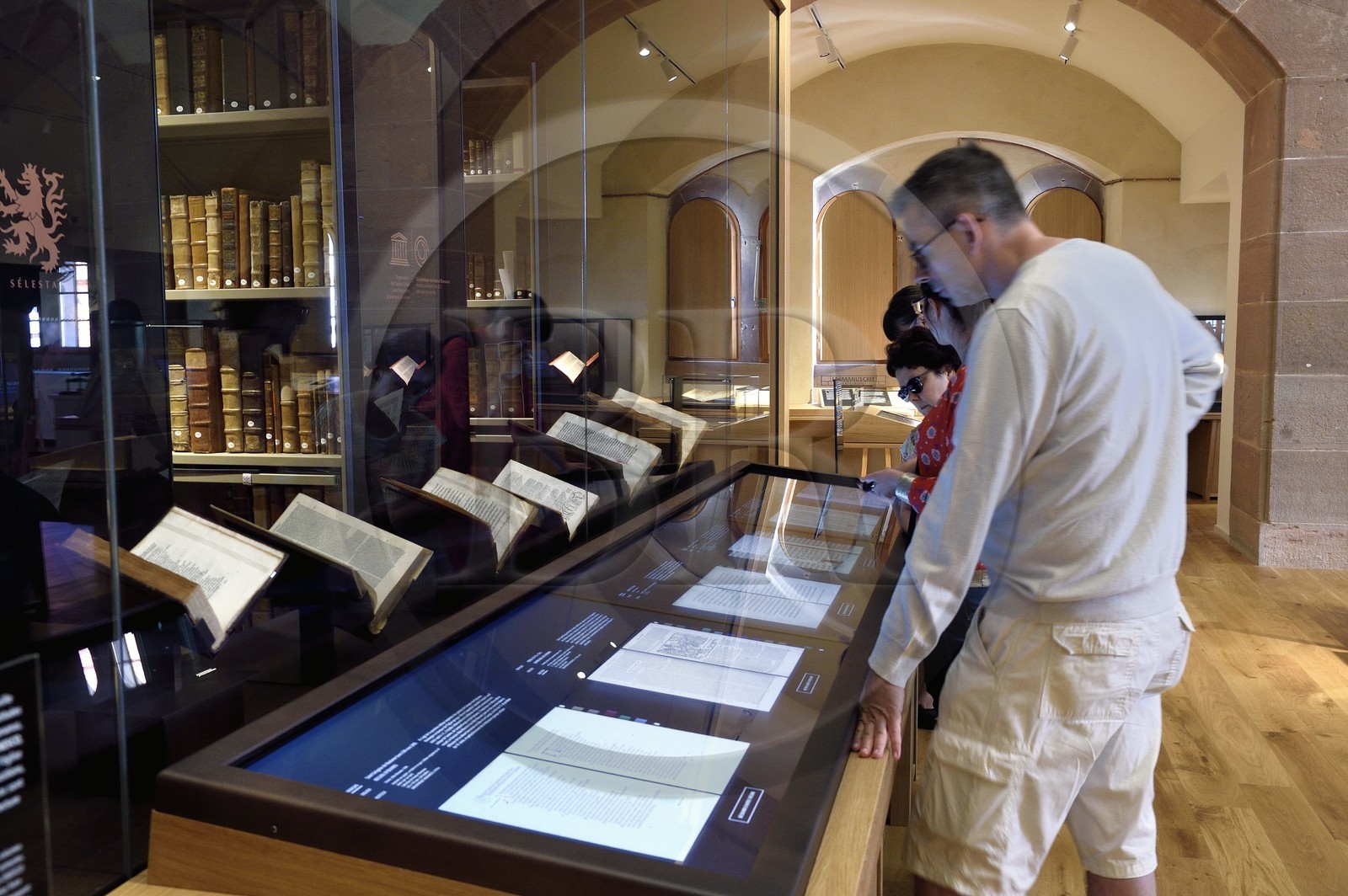 France, Bas-Rhin (67), Selestat, la Bibliothèque humaniste réaménagée par l'architecte Rudy Ricciotti, lecture en numérique des livres présentés à l'arrière des écrans, la bibliothèque personnelle de Beatus Rhenanus (1485-1547) est en arrière plan dans la pièce vitrée