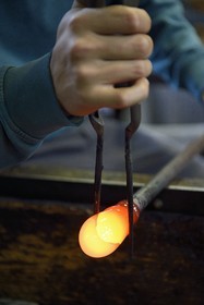 France, Moselle (57), Meisenthal, Centre international d’Art verrier (CIAV), l'atelier de soufflage, fabrication artisanale d'une boule de Noël, le souffleur régularise la masse au marbre tout en effectuant une rotation continue de sa canne