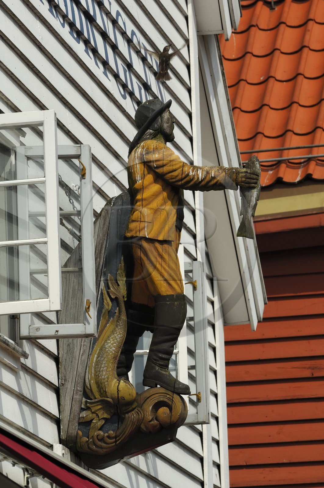 Norway, Hordaland, Bergen, fisherman statue on a wooden house facade