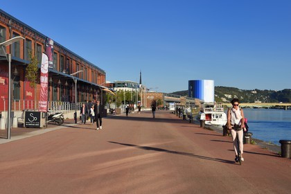 France, Seine Maritime, Rouen, woman on a push scooter and the Panorama XXL on the right bank of the Seine in the background