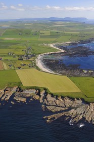 Royaume-Uni, Ecosse, Iles Orcades, Ile de Mainland, Brough Head, le Palais du comte (Earl's Palace) à St. Magnus House et fermes éparses dans les champs en bordure de mer à Birsay, Ward Hill qui est la plus haute colline dans les Orcades sur l'Ile de Hoy à l'horizon (vue aérienne)
